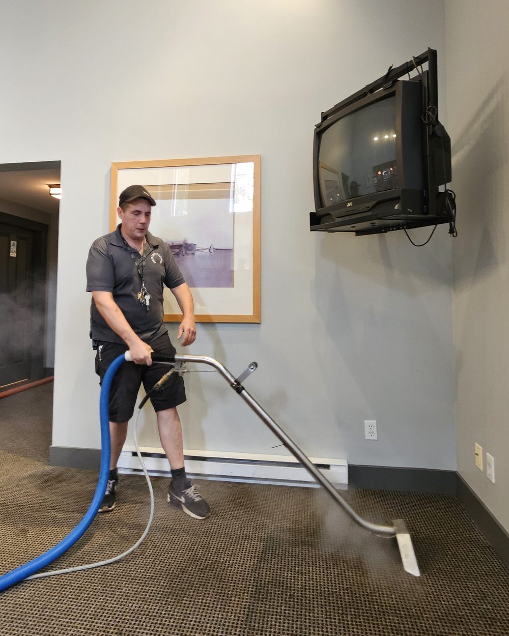 A Power Carpet Cleaners technician steam cleaning a carpet, with steam rising from the wand